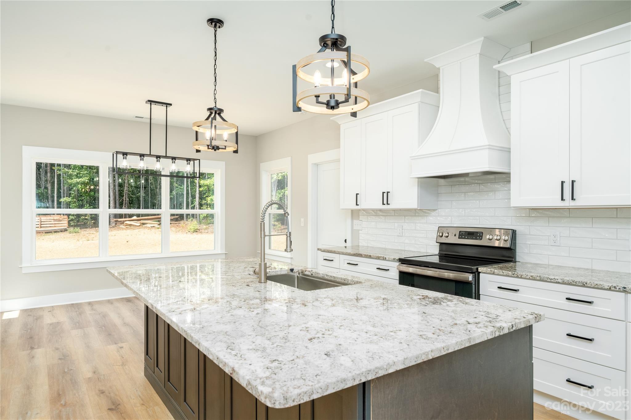 2512 Shuford Road, Unit 7A Lincolnton, NC 28092 - Photo 10 of 27 a kitchen with kitchen island granite countertop wooden cabinets and a chandelier