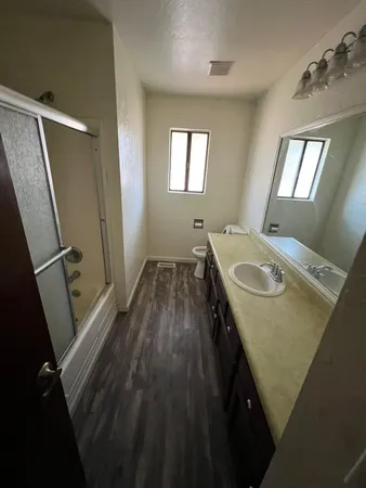 a kitchen with a sink and wooden floor