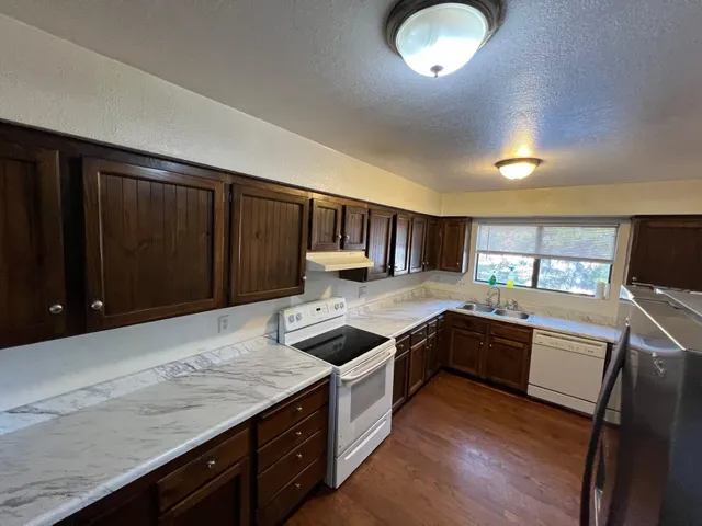 a kitchen with stainless steel appliances granite countertop a stove and a sink