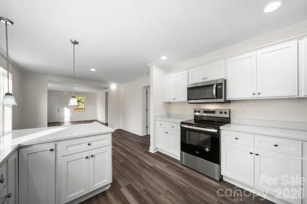 a large kitchen with cabinets stainless steel appliances and a counter space