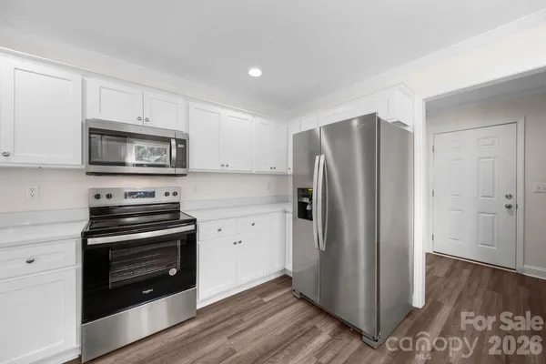 a kitchen with a refrigerator stove and wooden cabinets