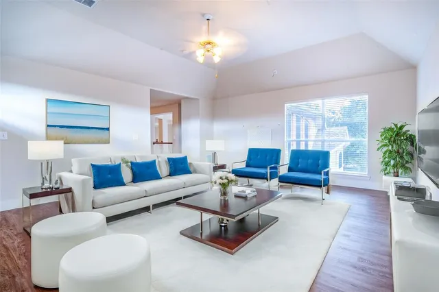 a living room with furniture a chandelier and a rug