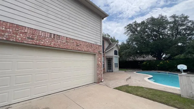 a view of a house with a yard and potted plants
