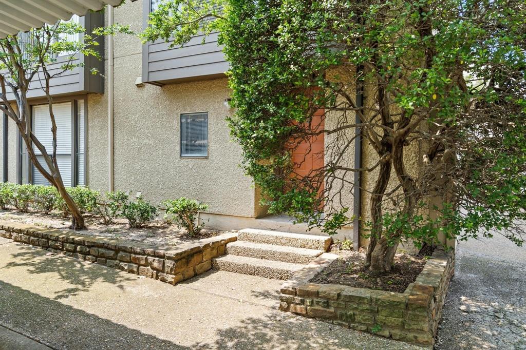 a view of a house with potted plants and large trees