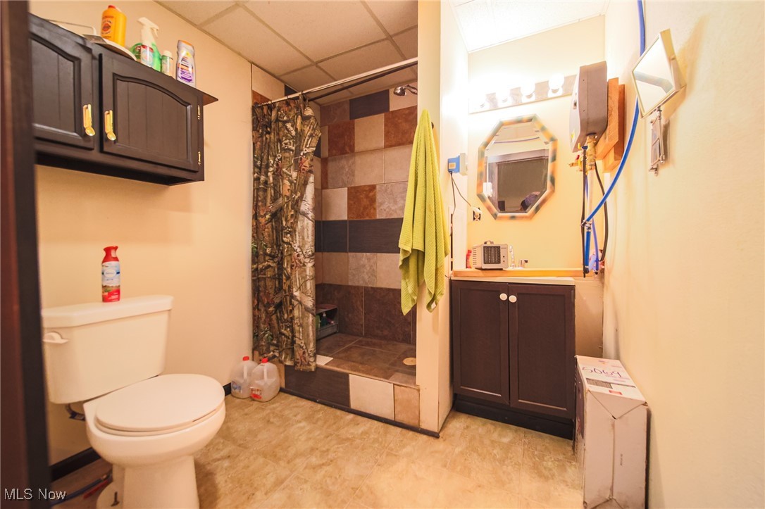4880 Post Road Jewett, OH 43986 - Photo 11 of 50 Bathroom featuring toilet, a tile shower, vanity, and a drop ceiling