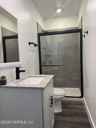 a bathroom with a granite countertop sink toilet and shower