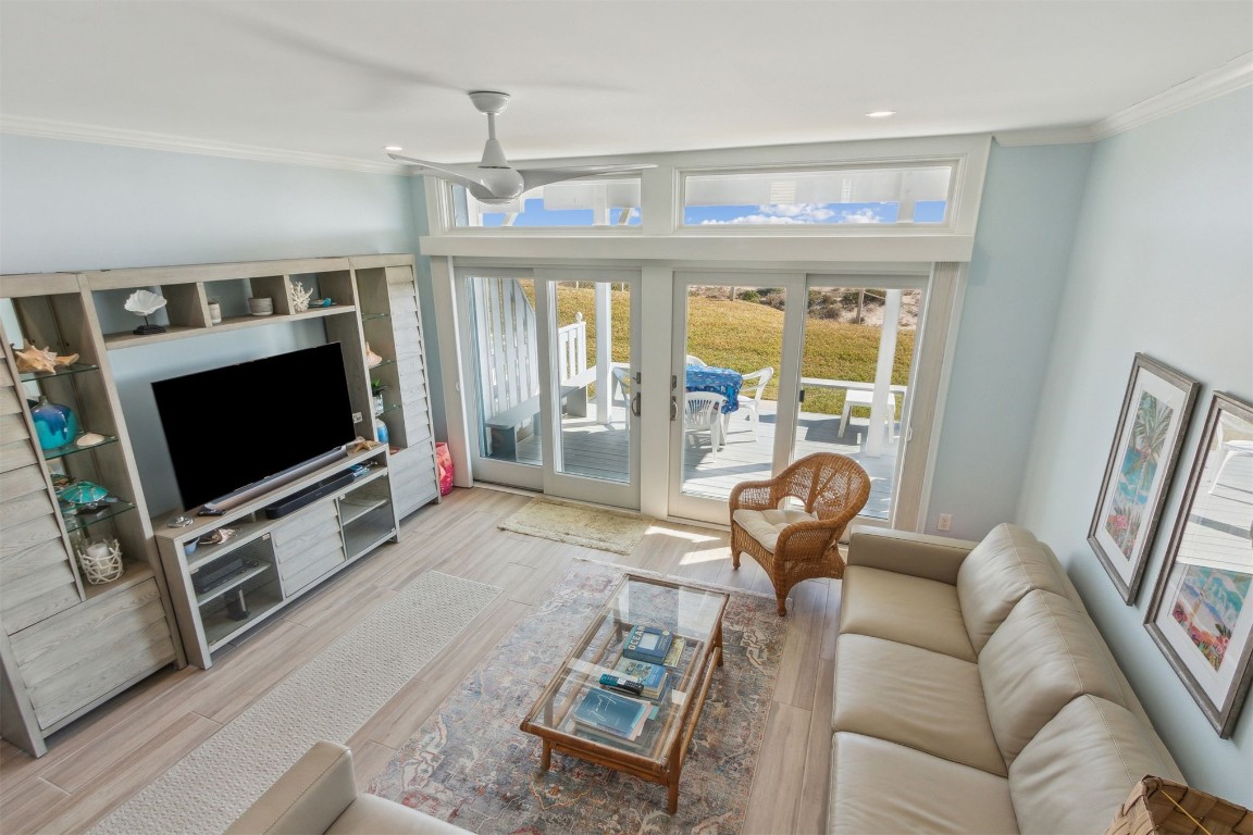 95078 Sandpiper Loop Fernandina Beach, FL 32034 - Photo 10 of 38 a living room with furniture a flat screen tv and a floor to ceiling window