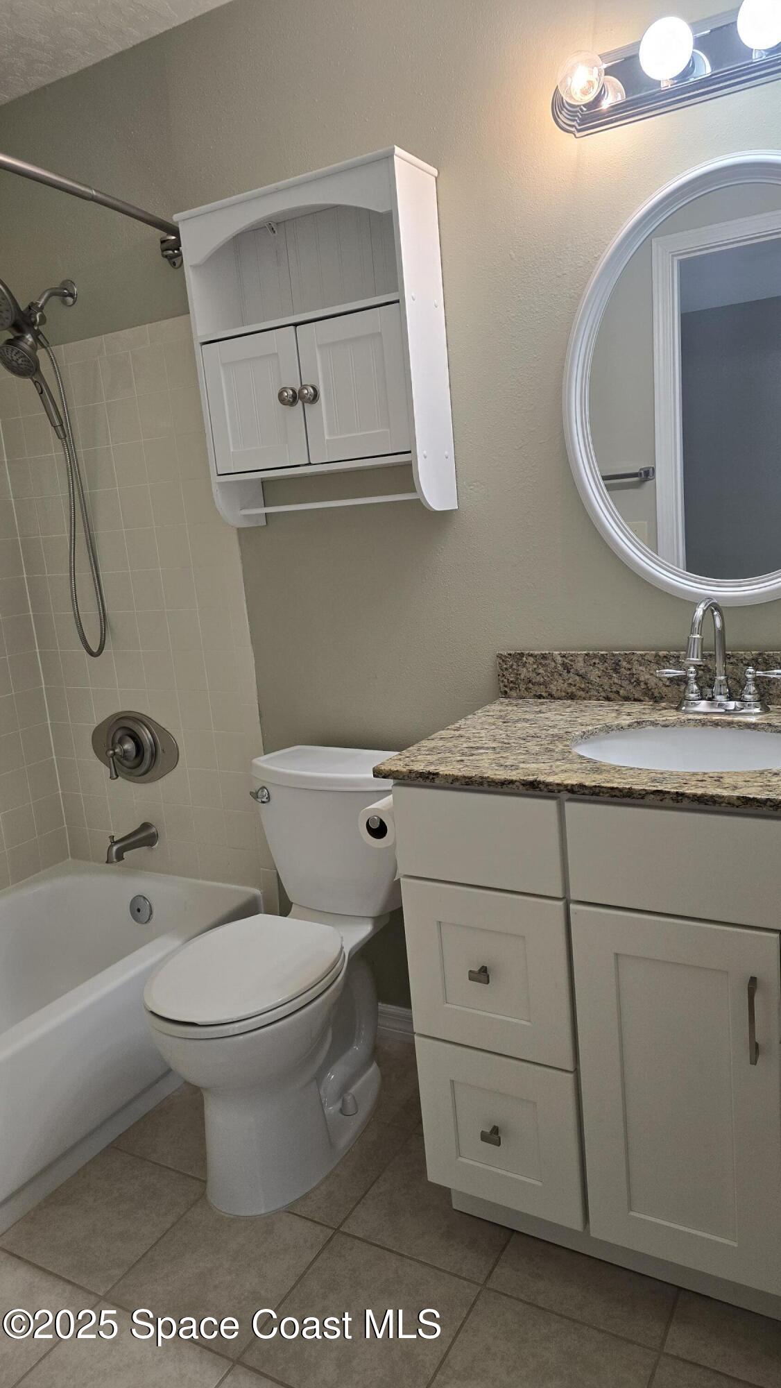 7667 North Wickham Road, Unit 1116 Melbourne, FL 32940 - Photo 23 of 34 a bathroom with a granite countertop toilet sink and mirror