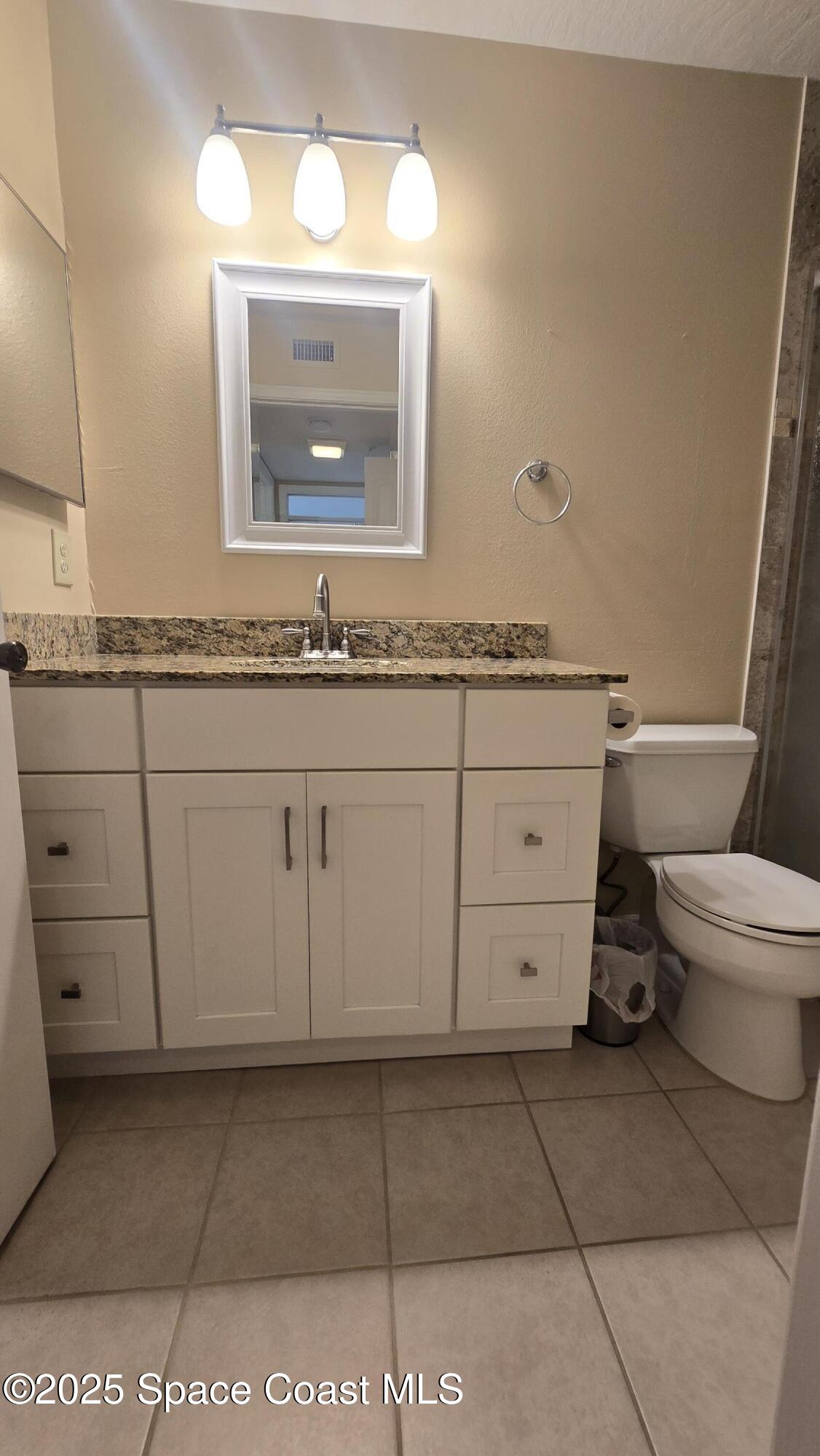 7667 North Wickham Road, Unit 1116 Melbourne, FL 32940 - Photo 27 of 34 a bathroom with a toilet sink and mirror