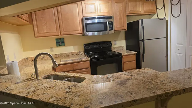 a kitchen with a refrigerator and a stove top oven