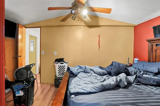 a bedroom with a bed and wooden floor