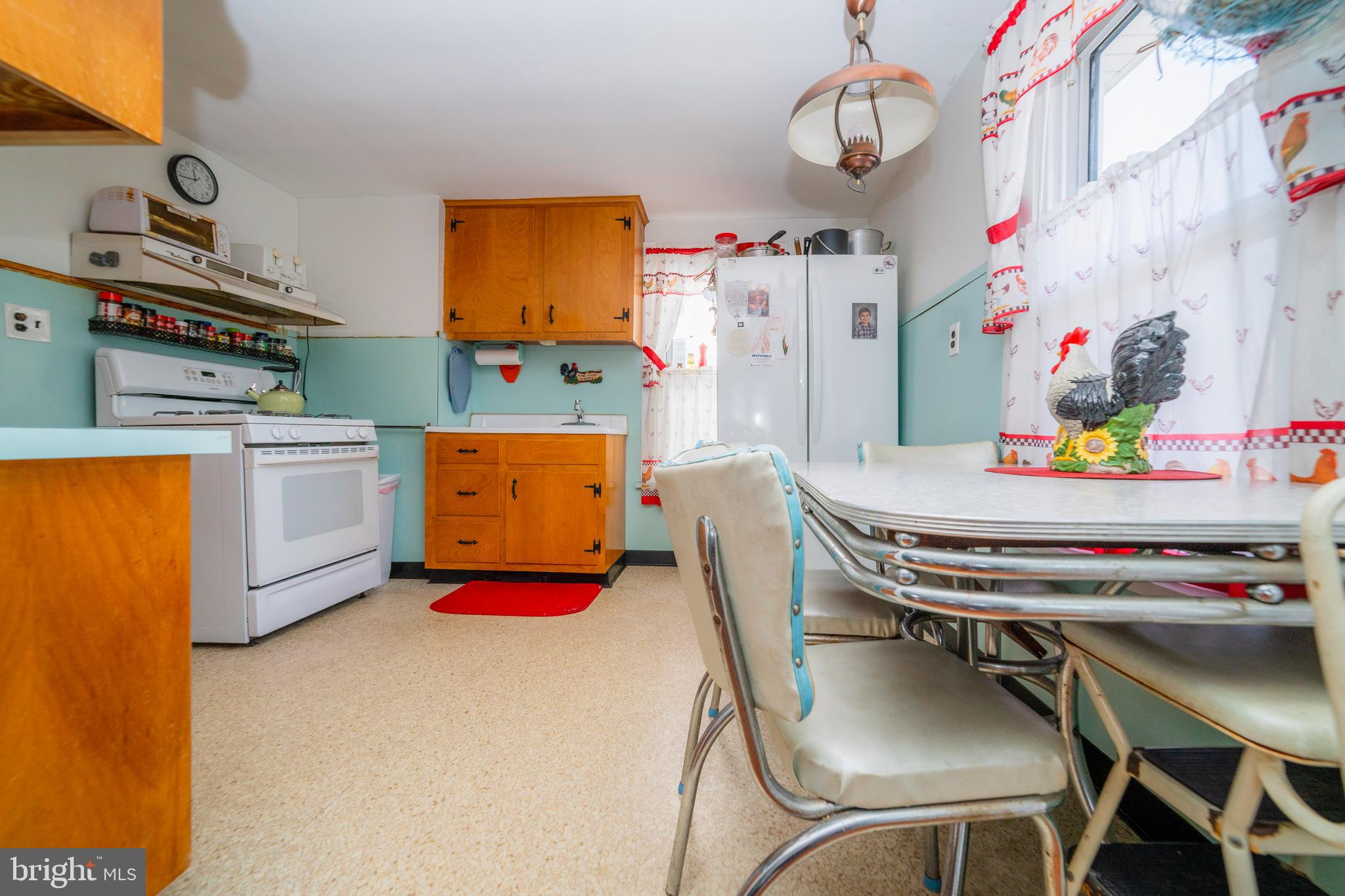 7 Chestnut Parkway Wallingford, PA 19086 - Photo 50 of 50 a kitchen with stainless steel appliances a stove a chimney a dining table and chairs with wooden floor