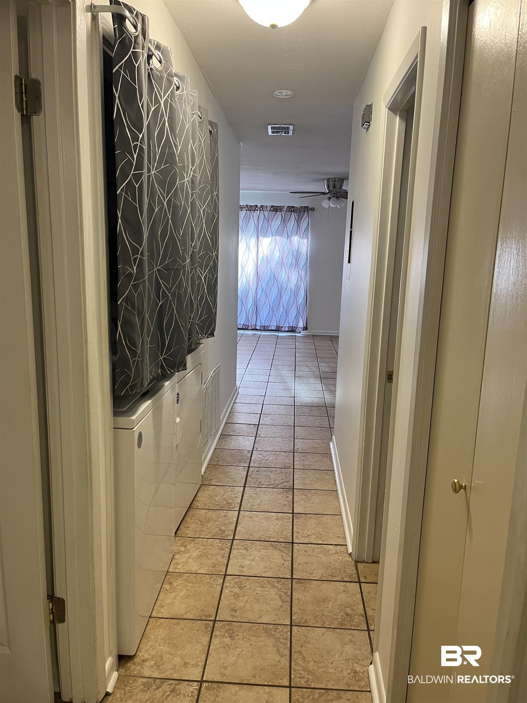 1146 North Alston Street Foley, AL 36535 - Photo 17 of 20 Hall with light tile patterned floors and washer / dryer