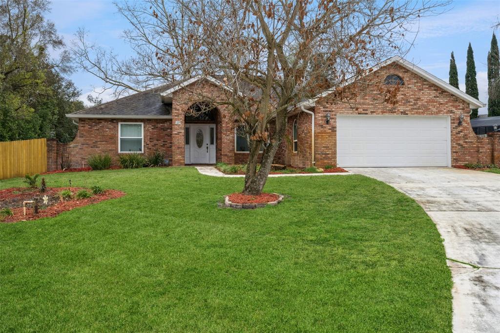 a front view of a house with a yard and trees