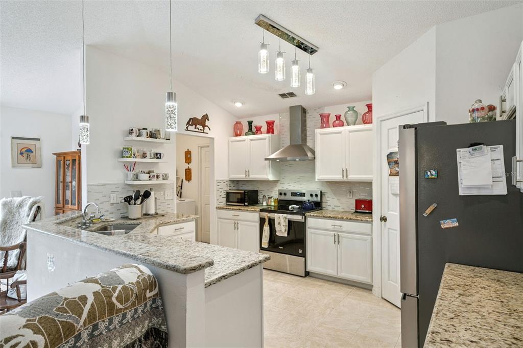 109 Hunter Point Court DeBary, FL 32713 - Photo 13 of 29 a kitchen with granite countertop a sink stove and refrigerator