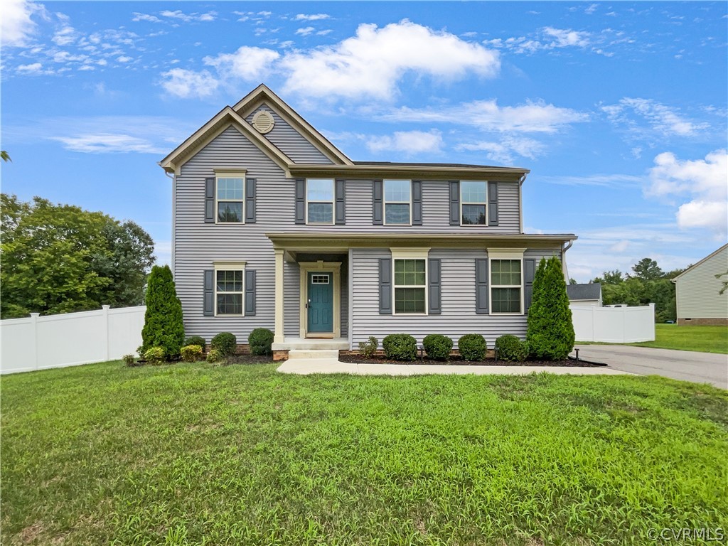 a front view of a house with a yard and trees