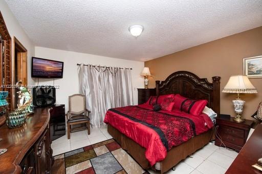 14025 Southwest 56th Terrace Miami, FL 33183 - Photo 2 of 8 a bedroom with a bed and a flat screen tv
