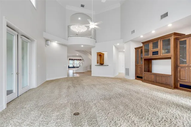 a view of an empty room with a window and a kitchen