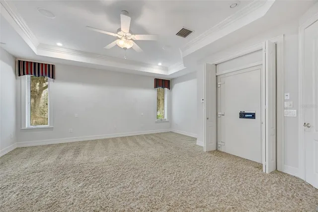 a big room with windows and a ceiling fan