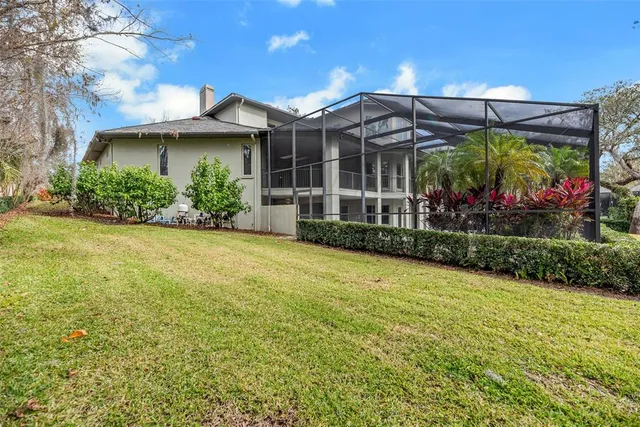 a view of a white house with a big yard and potted plants
