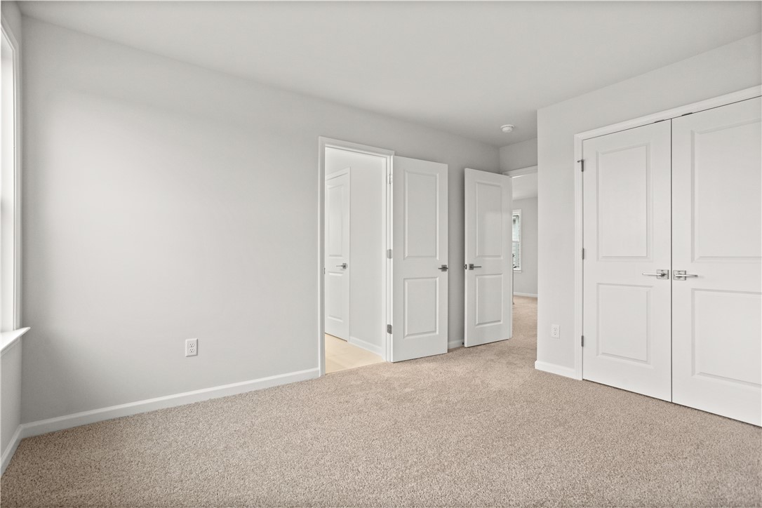 631 Sweetspire Trail, Unit 148 Seneca, SC 29678 - Photo 13 of 36 A well-lit, neutral-toned bedroom features soft carpet flooring and classic white doors.