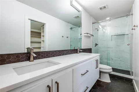 a bathroom with a sink a toilet and shower