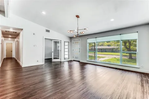 a view of empty room with wooden floor and fireplace