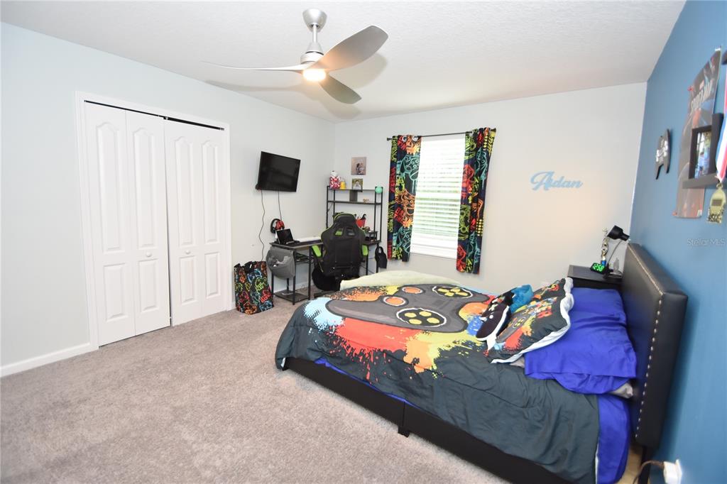 124 Oakleaf Way Palm Coast, FL 32137 - Photo 23 of 36 a bed room with a bed window and a flat screen tv