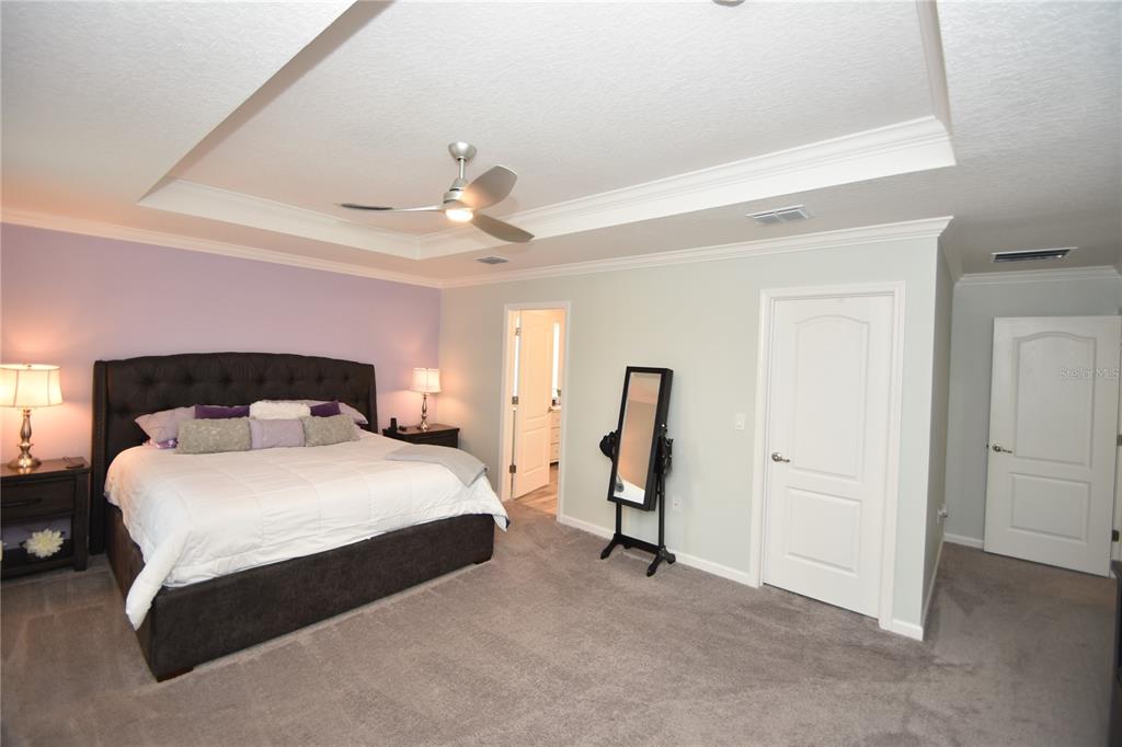 124 Oakleaf Way Palm Coast, FL 32137 - Photo 24 of 36 a bedroom with a bed and a chandelier