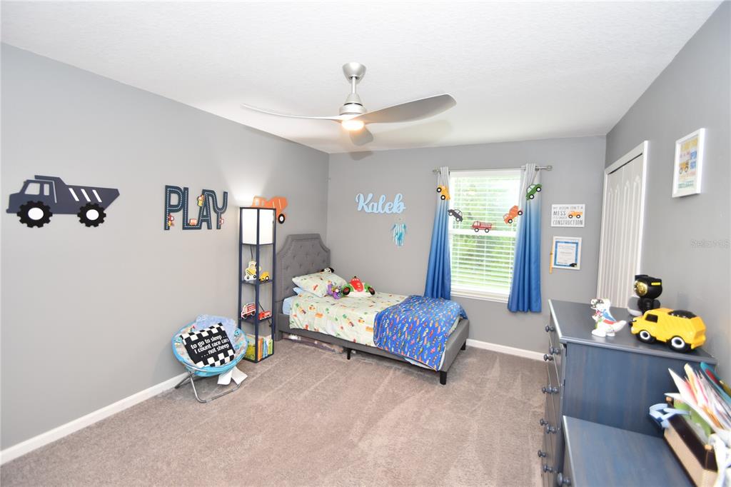 124 Oakleaf Way Palm Coast, FL 32137 - Photo 31 of 36 a bedroom with a bed and a chandelier