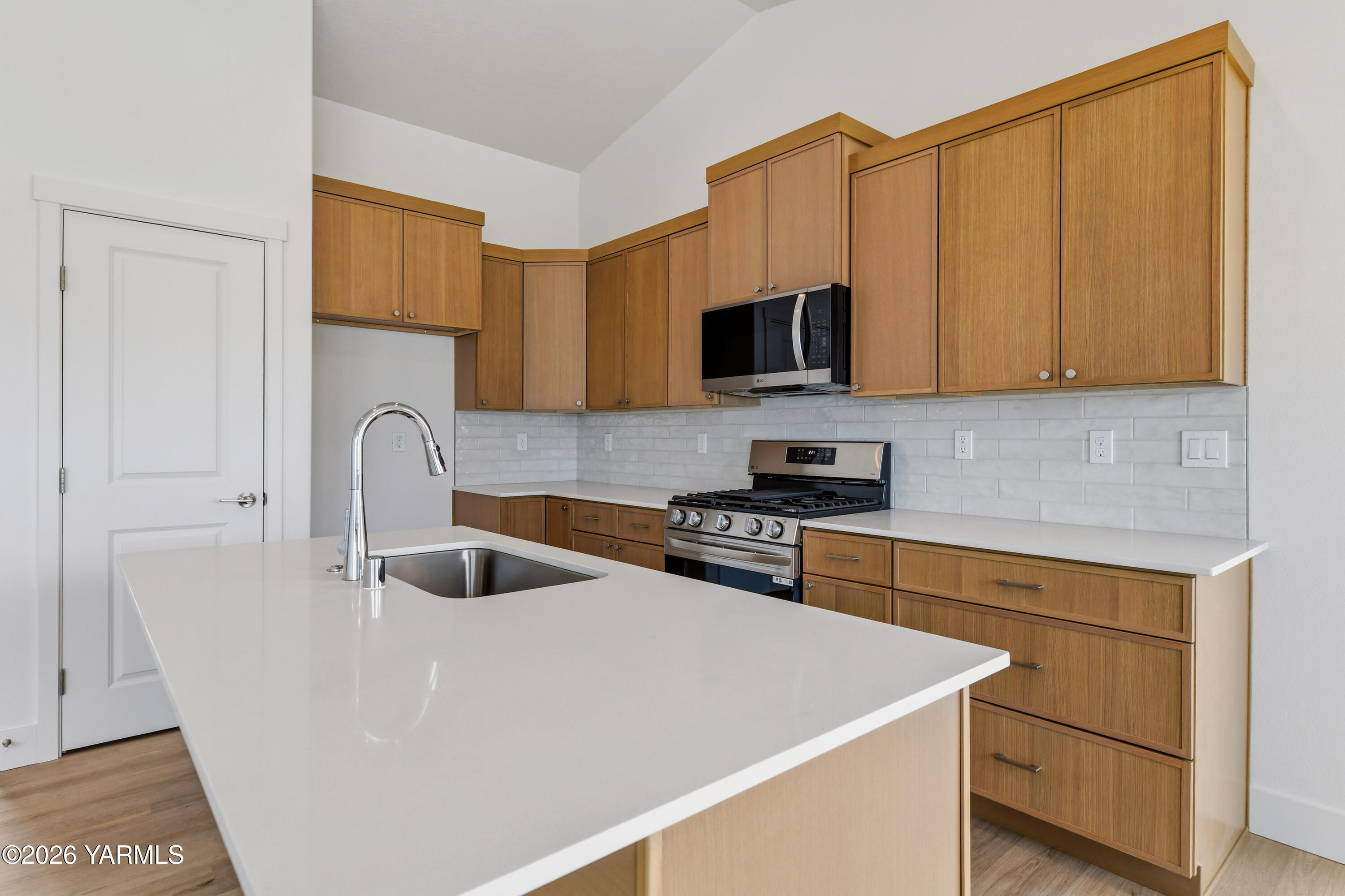 606 Grapevine Street, Unit PHASE 3 LOT 8) SPEC Grandview, WA 98930 - Photo 12 of 28 a kitchen with stainless steel appliances granite countertop a sink a stove and a microwave