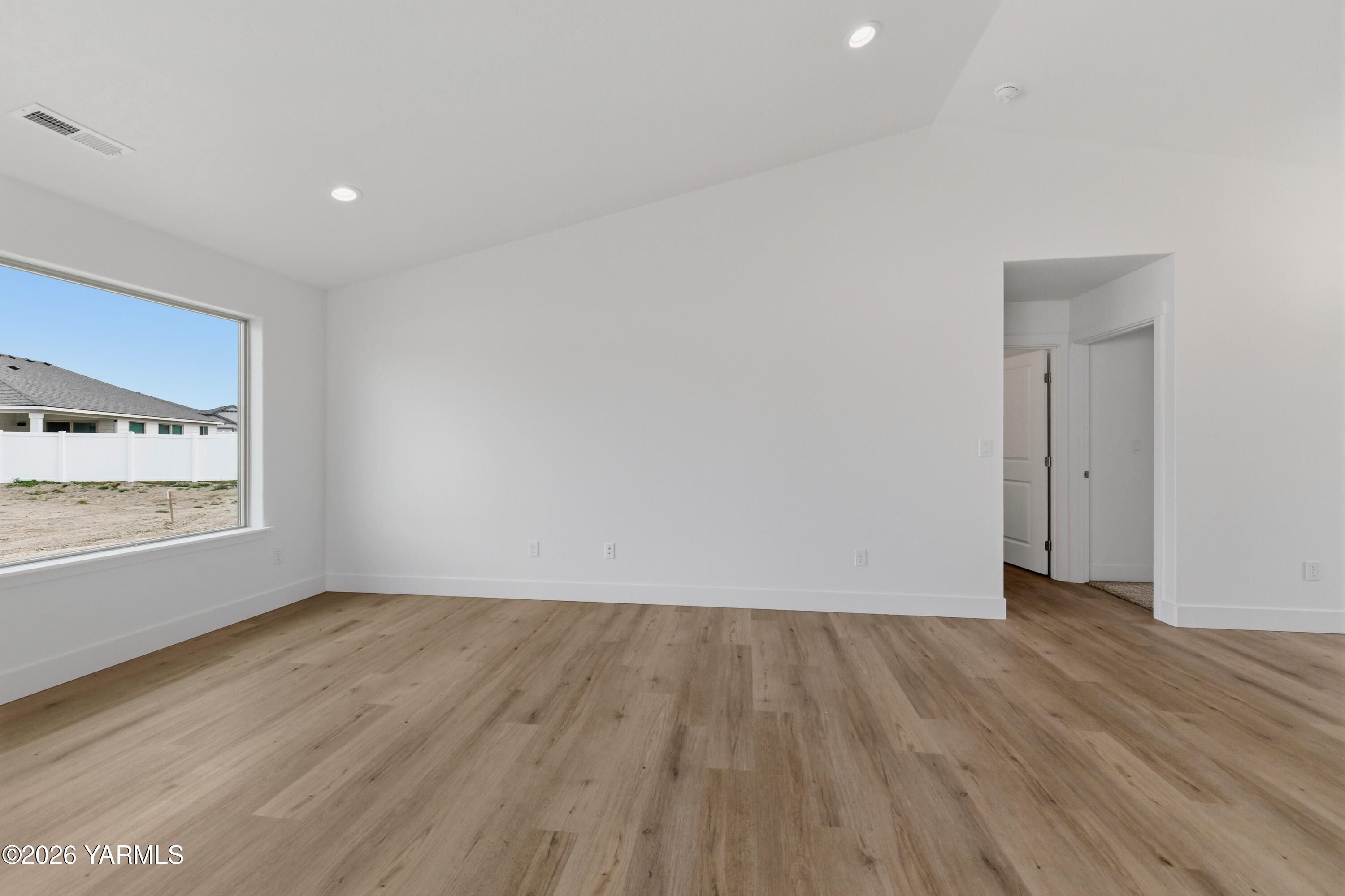 606 Grapevine Street, Unit PHASE 3 LOT 8) SPEC Grandview, WA 98930 - Photo 17 of 28 a view of an empty room with wooden floor and a window