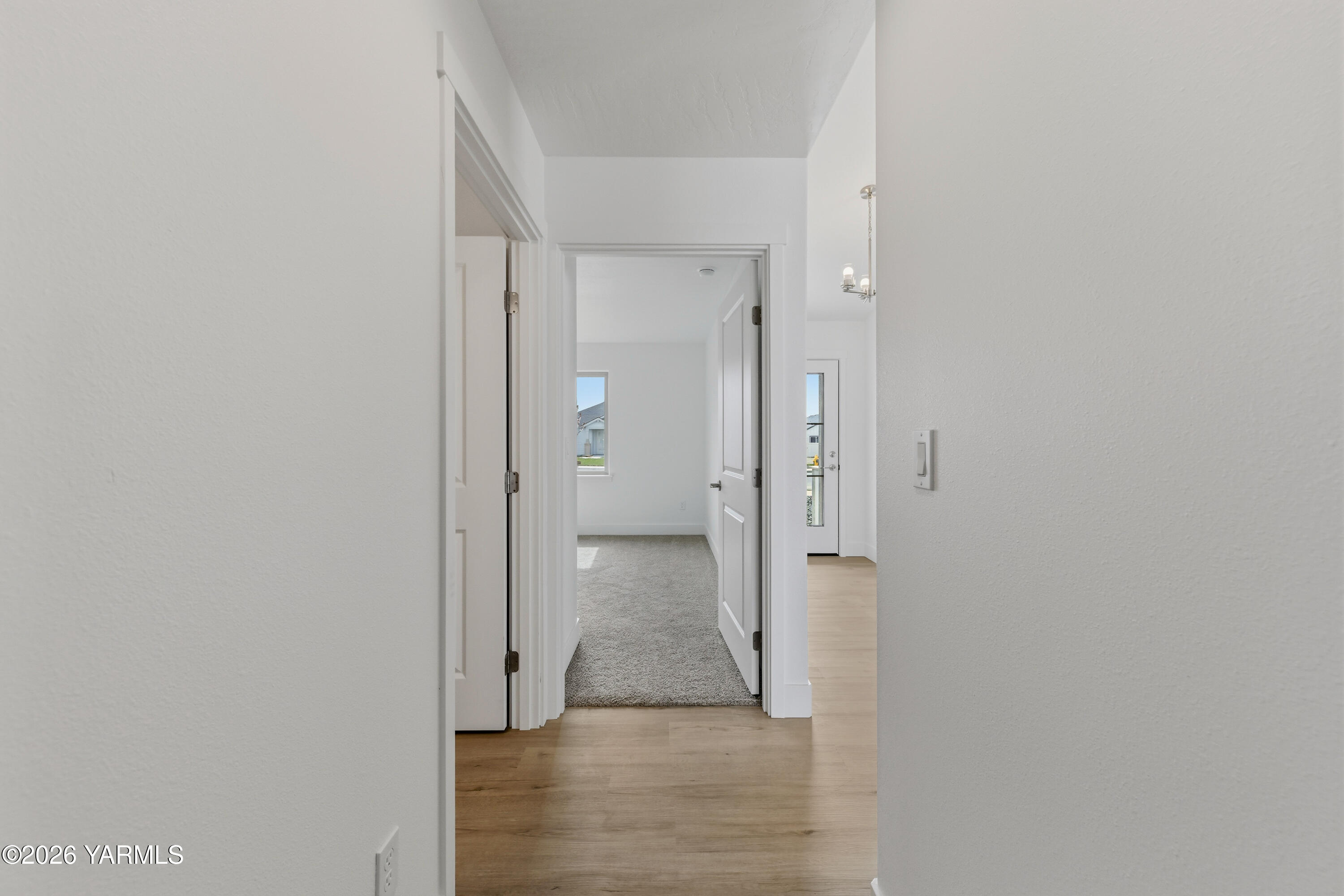 606 Grapevine Street, Unit PHASE 3 LOT 8) SPEC Grandview, WA 98930 - Photo 10 of 28 a view of a hallway with wooden floor and a bathroom