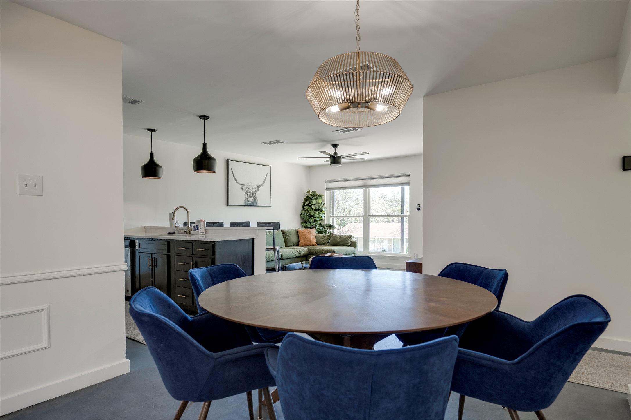 3606 Wilson Street Austin, TX 78704 - Photo 12 of 34 Dining space featuring a ceiling fan, a chandelier, and concrete flooring