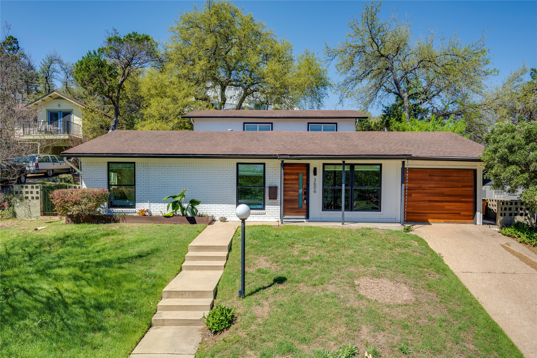 3606 Wilson Street Austin, TX 78704 - Photo 25 of 34 Mid-century home featuring brick siding, an attached garage, concrete driveway, and a shingled roof
