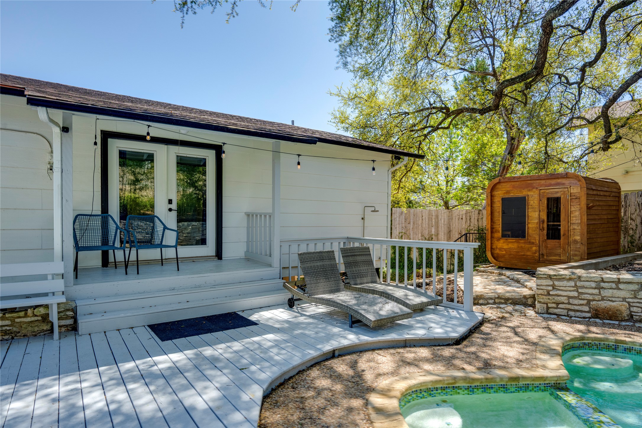 3606 Wilson Street Austin, TX 78704 - Photo 30 of 34 Wooden deck with french doors, an in-ground hot tub, and a storage unit