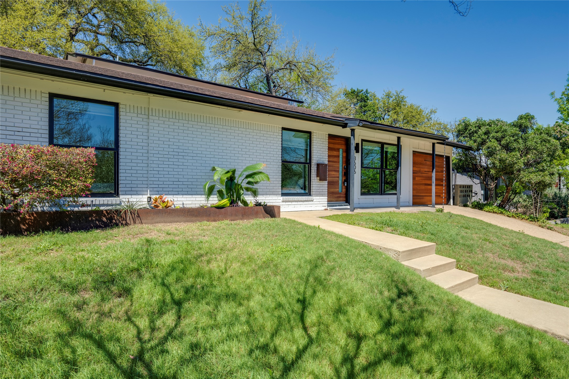 3606 Wilson Street Austin, TX 78704 - Photo 33 of 34 View of front of property featuring brick siding, a front yard, and an attached garage