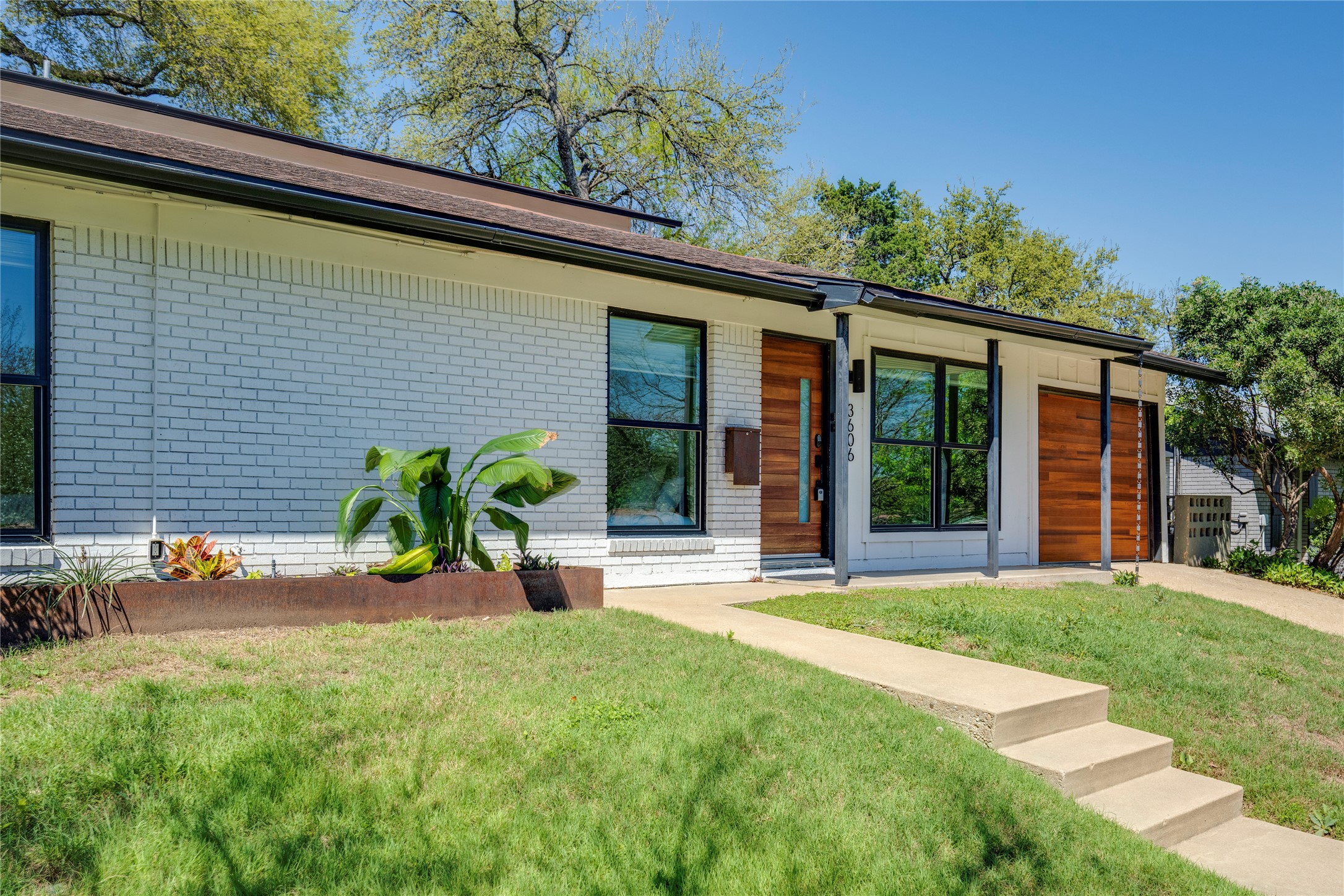 3606 Wilson Street Austin, TX 78704 - Photo 34 of 34 View of front of home with brick siding, a front lawn, a garage, and concrete driveway