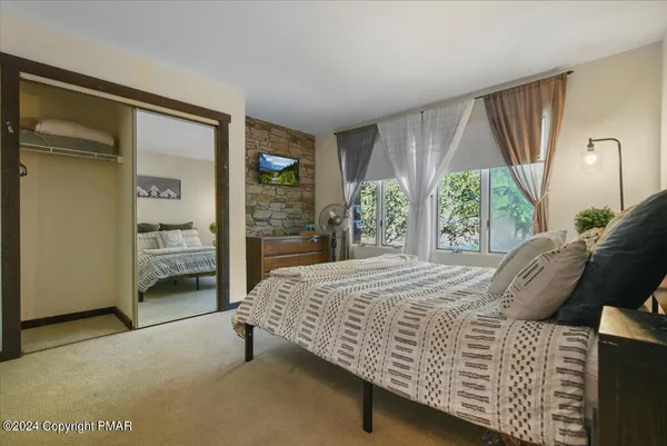 a bedroom with a bed and large window