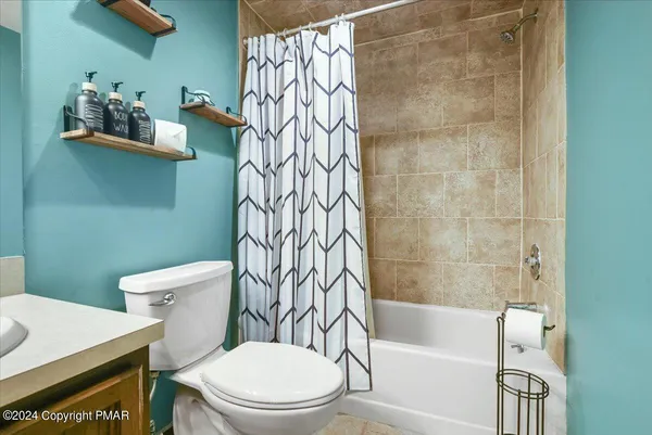 a white toilet sitting next to a bath tub