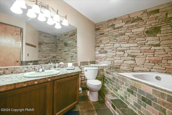 a bathroom with a sink a toilet and bathtub