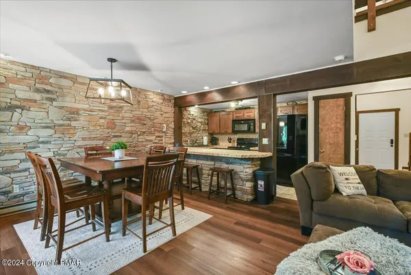 a kitchen with a table chairs stove and wooden floor