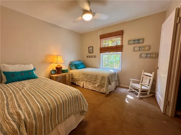 a bedroom with two beds and a chandelier