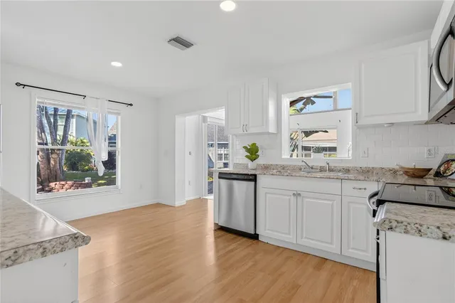 a kitchen with granite countertop a stove top oven sink and cabinets