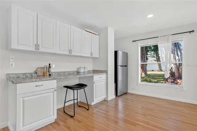 a kitchen with stainless steel appliances granite countertop a refrigerator sink and white cabinets