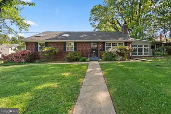 a front view of a house with a yard and potted plants