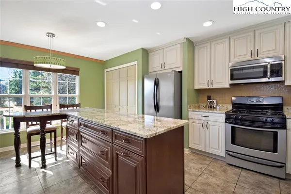 a kitchen with granite countertop a stove refrigerator and microwave