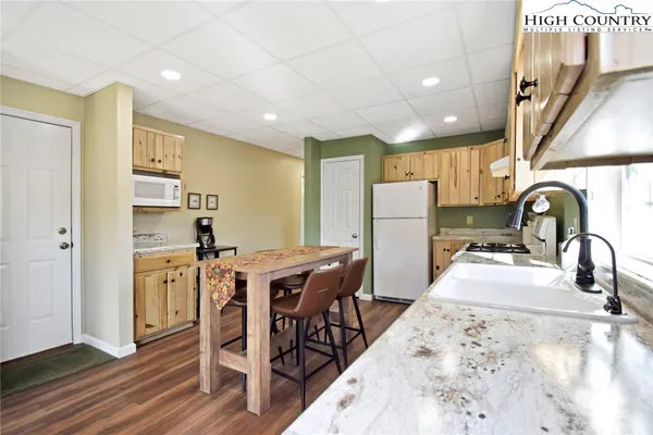 a kitchen with refrigerator a table and chairs