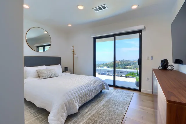 a bedroom with a bed and large windows