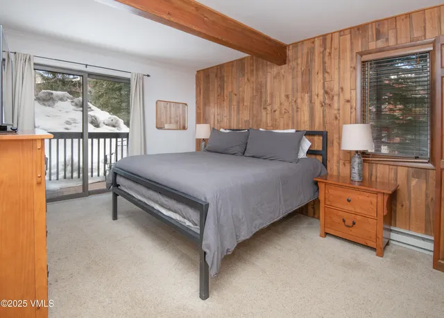a bedroom with a bed and large window